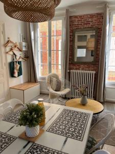 sala de estar con mesa y sillas en Coup de Cœur en Trouville-sur-Mer