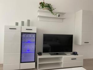 a living room with a television and a white cabinet at Centra apartamenti in Alūksne