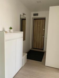 Cette chambre blanche dispose d'une porte et d'un miroir. dans l'établissement Centra apartamenti, à Alūksne