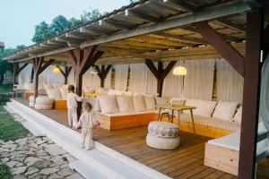 a woman and a child standing under a pergola at ECO Aparthotel The Dreamers's Club in Lumbarda