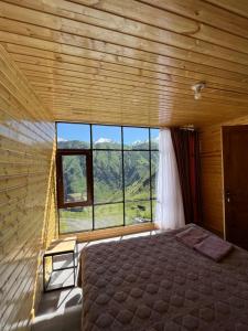 a bedroom with a bed and a large window at Ardoti Guest House in Ardoti