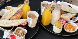 un piatto di cibo con pane e bottiglie di succo di Hôtel particulier - Les lodges du Bassin d'Arcachon- Petit-déjeuner sur demande- Prestations haut de gamme a Gujan-Mestras