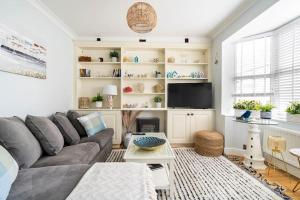 a living room with a couch and a tv at Gorgeous Beach House in Kent