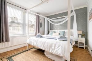 a bedroom with a canopy bed and a window at Gorgeous Beach House in Kent