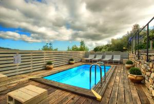 a swimming pool on a wooden deck with chairs at Chalet in Liguria in Vasia