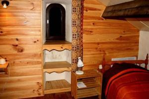 a bedroom in a log cabin with a bed at Maison Larzac Cevennes Grand Gite 