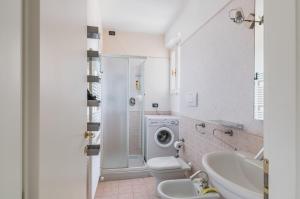 A due passi da Borgo San Giuliano Apartment في ريميني: حمام مع مرحاض ومغسلة وغسالة