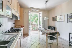 una cucina con tavolo e piano di lavoro di A due passi da Borgo San Giuliano Apartment a Rimini