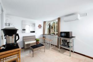 a room with a kitchen and a living room with a stove at Faraglionensis MonaconeHouse Apartment in Capri