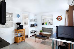 a living room with a tv and a table at Faraglionensis MonaconeHouse Apartment in Capri +15 photos