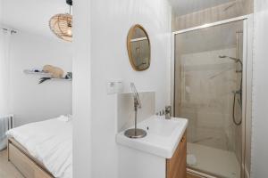 a white bathroom with a sink and a shower at Villa Maria Villa aan zee met privé parking 8p in Nieuwpoort +21 photos
