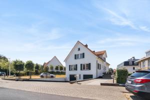 a white house with a car parked in front of it at Villa Maria Villa aan zee met privé parking 8p in Nieuwpoort