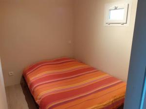 a striped bed in a corner of a room at La cabane au fond du jardin in Montrodat