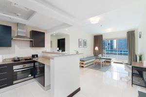 a kitchen with a counter and a living room at White Sage - Gorgeous Apartment in JLT Near the Metro Station in Dubai