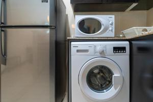 a kitchen with a washing machine and a refrigerator at White Sage - Gorgeous Apartment in JLT Near the Metro Station in Dubai