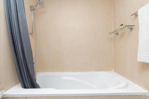 a bathroom with a shower with a white tub at White Sage - Gorgeous Apartment in JLT Near the Metro Station in Dubai