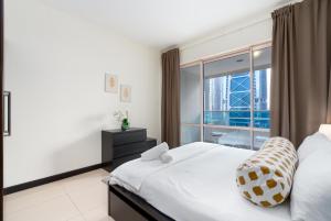 a bedroom with a bed and a large window at White Sage - Gorgeous Apartment in JLT Near the Metro Station in Dubai +36 photos