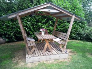 スパにあるL'écurie gîte duplex wellnessの木製のガゼボ(テーブル、椅子2脚付)