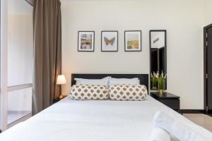 a bedroom with a large white bed with pillows at White Sage - Gorgeous Apartment in JLT Near the Metro Station in Dubai