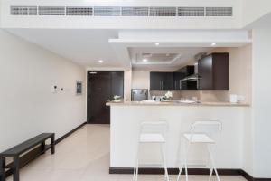 a kitchen with two white stools and a counter at White Sage - Gorgeous Apartment in JLT Near the Metro Station in Dubai