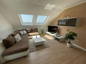 a living room with a couch and a flat screen tv at Ferienwohnung Hegaublick in Stockach