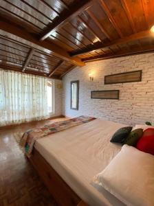 a large bed in a room with a brick wall at Villa Bliss Nest in Nainital
