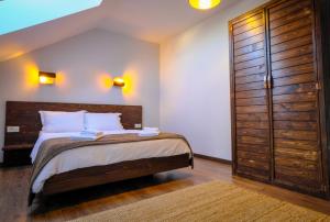 Un dormitorio con una cama y un gran armario de madera. en Popa Apartment en Cluj-Napoca