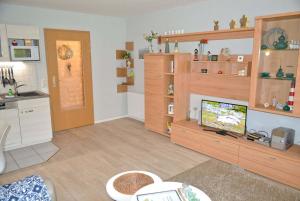 a living room with a tv and a kitchen at Zum Leuchtturm 10 Ferienwohnung Bi dat Blinkfuer in Westereck