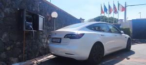 une voiture blanche garée à côté d'un mur en pierre dans l'établissement Etna Royal View, à Trecastagni