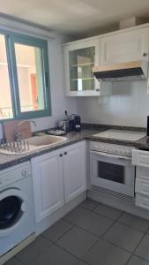 una cucina bianca con lavandino e lavastoviglie di BEACH VALENCIA 22 Apartment facing the sea with frontal views a Valencia