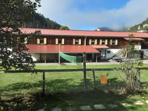 a building with a hammock in front of it at Hostel Le Chandelier in Saint-Ursanne