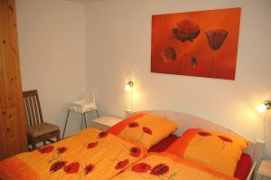 WestereckにあるZum Leuchtturm 10 Ferienwohnung Nr 05のベッドルーム1室(赤い花のベッド2台付)