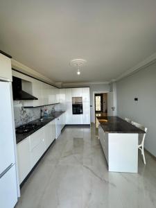 uma cozinha com armários brancos e um balcão preto em Sea View Villa em Trabzon