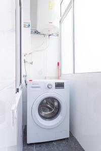 uma máquina de lavar e secar roupa num quarto branco com uma janela em Myflats Beach Side Santa Pola em Santa Pola