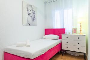 2 camas num quarto com uma cabeceira cor-de-rosa e uma cómoda em Myflats Beach Side Santa Pola em Santa Pola