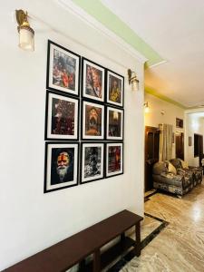 un ensemble de photos sur un mur dans un salon dans l'établissement Paridhi, à Varanasi