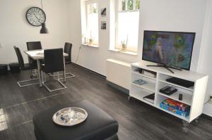 WestereckにあるZum Leuchtturm 10 Ferienwohnung Nr 07のテレビとテーブルと椅子のあるリビングルーム
