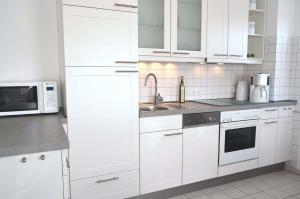 WestereckにあるZum Leuchtturm 10 Ferienwohnung Nr 07の白いキッチン(白いキャビネット、シンク付)