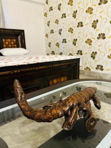 une statue d'un scorpion sur une table à côté d'un lit dans l'établissement Paridhi, à Varanasi