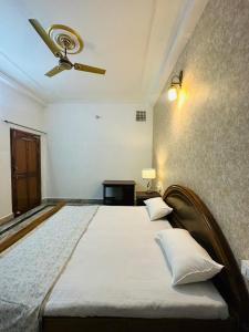 a bedroom with a large bed with a ceiling fan at Paridhi in Varanasi