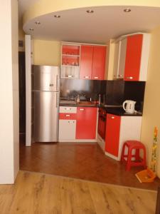 a kitchen with red cabinets and a stainless steel refrigerator at APARTMENT 8 Primorsko АПАРТАМЕНТ 8 Приморско in Primorsko