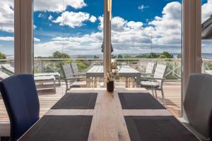 a dining room with a table and chairs on a deck at Villa Am alten Kreidebruch_ Pentho in Sassnitz