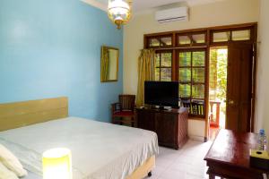 a bedroom with a bed and a tv in it at Hotel Tulips in Yogyakarta