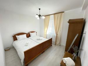 Un dormitorio con una cama grande y una ventana en Cazare apartamente LAVI-TOUR Tg Neamț en Tîrgu Neamţ