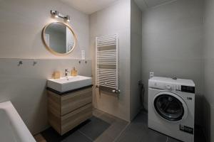 a bathroom with a sink and a washing machine at SKAU Blue Residence in Sky Park 21 floor 2 tower Panoramic View Free Parking in Bratislava