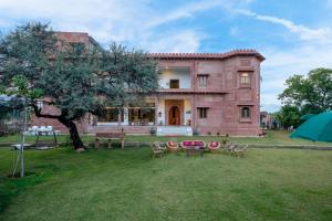 a large house with chairs and a table in the yard at Castle Oodeypore A Boutique stay Udaipur in Udaipur