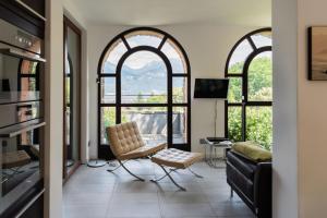 a living room with two large windows and a couch at Casa Penny - Menaggio in Menaggio