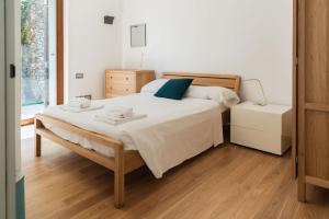 a bedroom with a large bed with white sheets and blue pillows at Casa Penny - Menaggio by LoveComo in Menaggio +22 photos