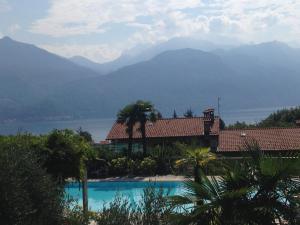 a resort with a swimming pool with mountains in the background at Casa Penny - Menaggio by LoveComo in Menaggio