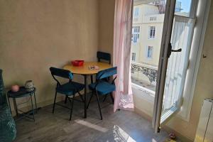 a small table and chairs in a room with a window at Renovated apartment near the beach in Villers-sur-Mer